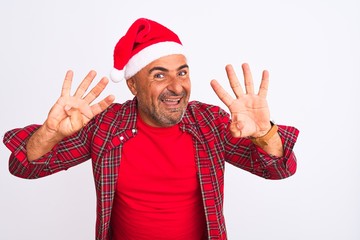 Middle age man wearing Christmas Santa hat standing over isolated white background showing and pointing up with fingers number nine while smiling confident and happy.