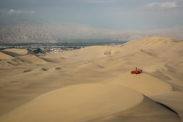 Fototapeta na wymiar A red buggy in the desert of Ica