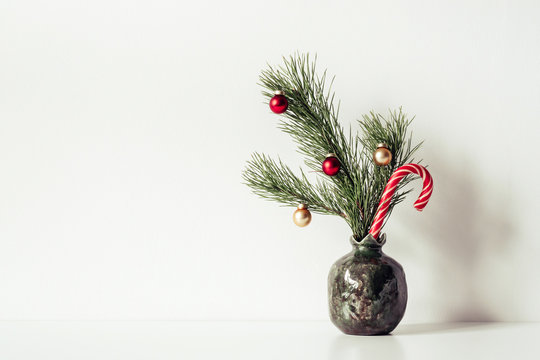 White Composition with little decorated Christmas tree in vase. Copy space for text or lettering