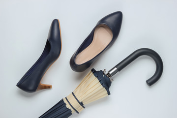 Classic high heel shoes, umbrella on white background. Minimalism fashion concept. Top view