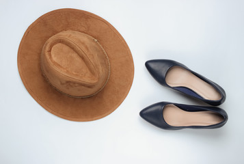 Felt hat, high heel shoes on a white background. Minimalistic fashion concept. Top view