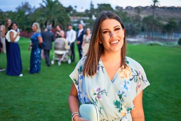 Young beautiful and elegant woman with wedding guest dress smiling happy and cheerful