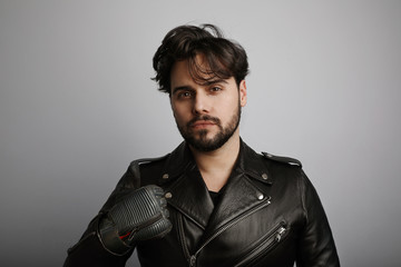 Studio portrait of young bearded hipster looking at the camera.