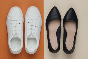 Leather high heel shoes and sneakers on colored background. Minimalistic fashion concept. Studio shot