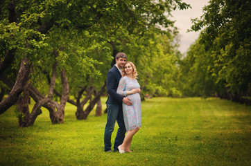 image of beautiful pregnant woman and her handsome husband hugging the tummy 