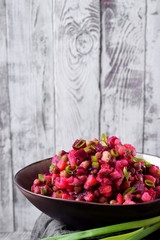 Vinaigrette salad in a ceramic bowl against the white wooden wall. Russian cuisine meal
