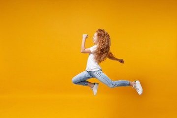 Side view of little ginger kid girl 12-13 years old in white t-shirt isolated on yellow background...