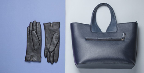 Women's fashion accessories on a gray-purple background. Leather bag, gloves. Top view