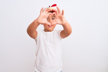 Beautiful kid boy wearing fanny colorful cap with propeller over isolated white background smiling in love showing heart symbol and shape with hands. Romantic concept.