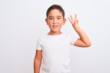 Beautiful kid boy wearing casual t-shirt standing over isolated white background showing and pointing up with fingers number three while smiling confident and happy.