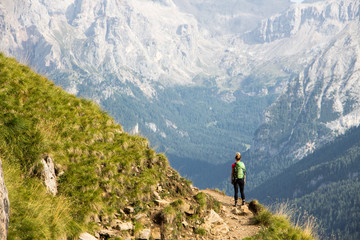 Italy dolomites lonely hiker in front of massive mountain rocks view marmolada