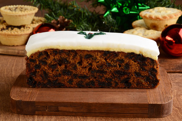 closeup fruit cake with desserts in background