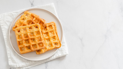 Perfect savory keto waffles. Two ingredients chaffles on plate over white marble background. Eggs and parmesan cheese low carb waffles. Top view or flat lay. Copy space for text or design. Banner.