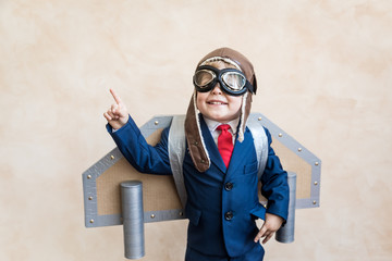 Portrait of young businessman with toy paper wings - obrazy, fototapety, plakaty