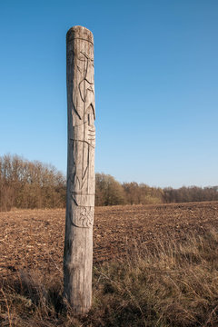 Wooden idol Slavic god Svarog on a background of blue sky
