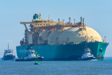 Barco mercante para el transporte de gas entrando a puerto acompañado de remolcadorescarga