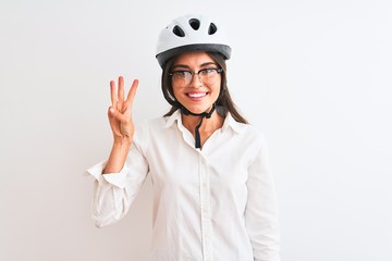 Beautiful businesswoman wearing glasses and bike helmet over isolated white background showing and pointing up with fingers number three while smiling confident and happy.
