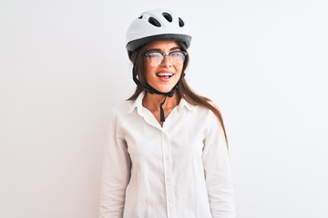 Beautiful businesswoman wearing glasses and bike helmet over isolated white background winking...