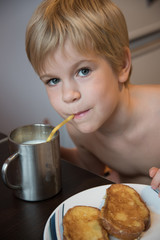 The child drinks milk at breakfast. Milk and croutons.