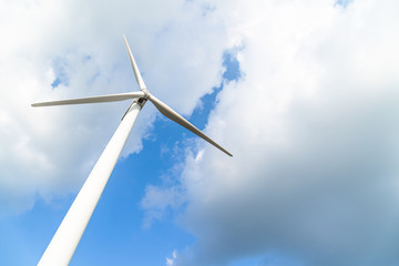 Wind turbine against a cloudy blue sky