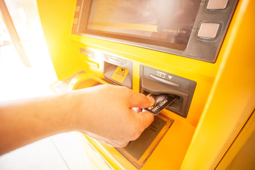Hand with a credit card, using an ATM. Woman using an atm machine with his credit card.