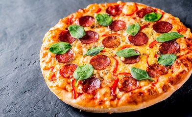 Pepperoni Pizza with Mozzarella cheese, salami, pepper, Spices and Fresh spinach. Italian pizza on...