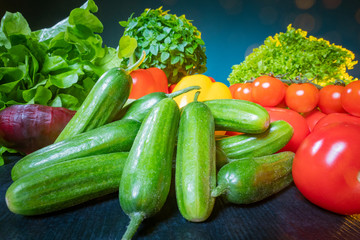 Vegetables for making a Greek salad. Fresh vegetables on the brown table. Cucumbers, tomatoes, onions, lettuce, arugula. Mediterranean diet. Wholesome food.