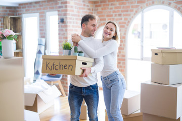 Young beautiful couple moving cardboard boxes at new home