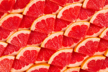 Grapefruit red juicy slices background. top view.