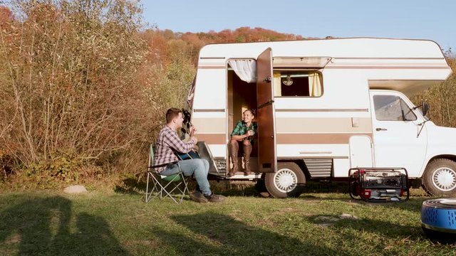 Beautiful girlfriend on the stairs of retro camper van