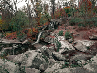 Wild landscape with a small creek, rocks and a lake. A small waterfall among the rocks. A small lake among the boulders