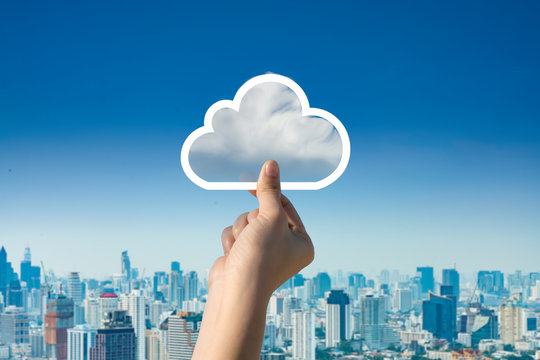 Concept of download on cloud storage.Woman hand holding picture on cloud sky background. The development of the imagination, copy space.