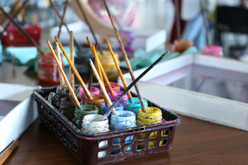 Cans of ebru paints with brushes stands on the table. Preparation for drawing aqua paints