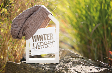 Wei&szlig;es Haus im Garten mit Schild Winter Herbst