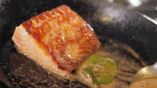 Grilled salmon fish with various vegetables on pan on the flaming grill