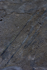 Background wall of an old dark stone with smudges of tar