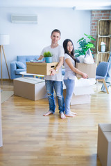 Fototapeta na wymiar Young beautiful couple moving cardboard boxes at new home