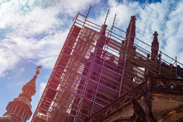 Fototapeta premium An ancient historical monument - Prague Castle, during the reconstruction surrounded by scaffolding at sunrise
