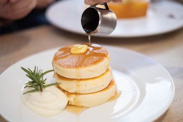 Honey pancakes and butter on the white dish.
