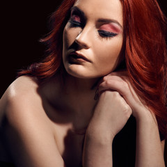 Fototapeta premium Fashionable portrait of beautiful redheaded model with naked shoulders on black background