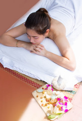 Top view of a woman is laying down on comfortable bed for aromatherapy