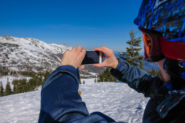 Young snowboarder riding in the mountains on a snowboard.