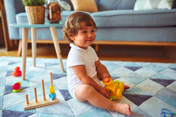 Beautiful toddler child girl playing with toys on the carpet