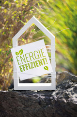 Weißes Haus im Garten mit Schild energieeffizient!
