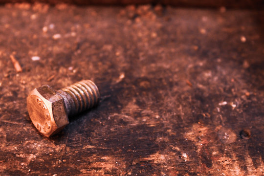 a steel screw on a wooden table