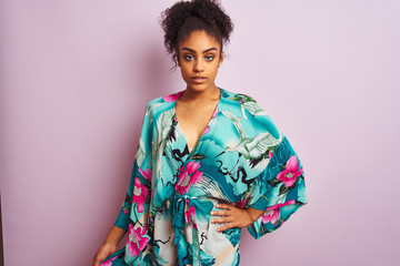 Young beautiful african american woman standing wearing elegant colorful caftan