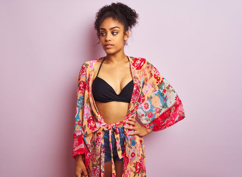 Young beautiful african american woman on vacation standing wearing bikini and colorful caftan