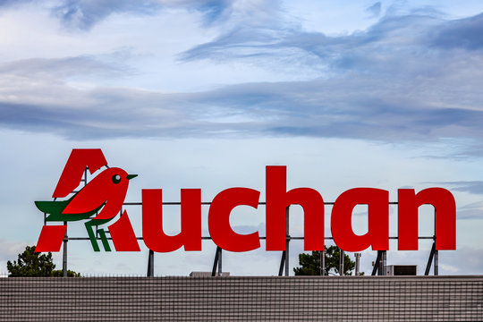 Coina, Portugal - October 23, 2019: Auchan logo or symbol in the Barreiro Planet Retail Park. Auchan is a French hypermarket, supermarket or superstore chain