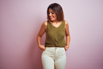 Young beautiful hispanic woman standing wearing green t-shirt