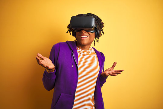 Young african american man playing virtual reality game using goggles